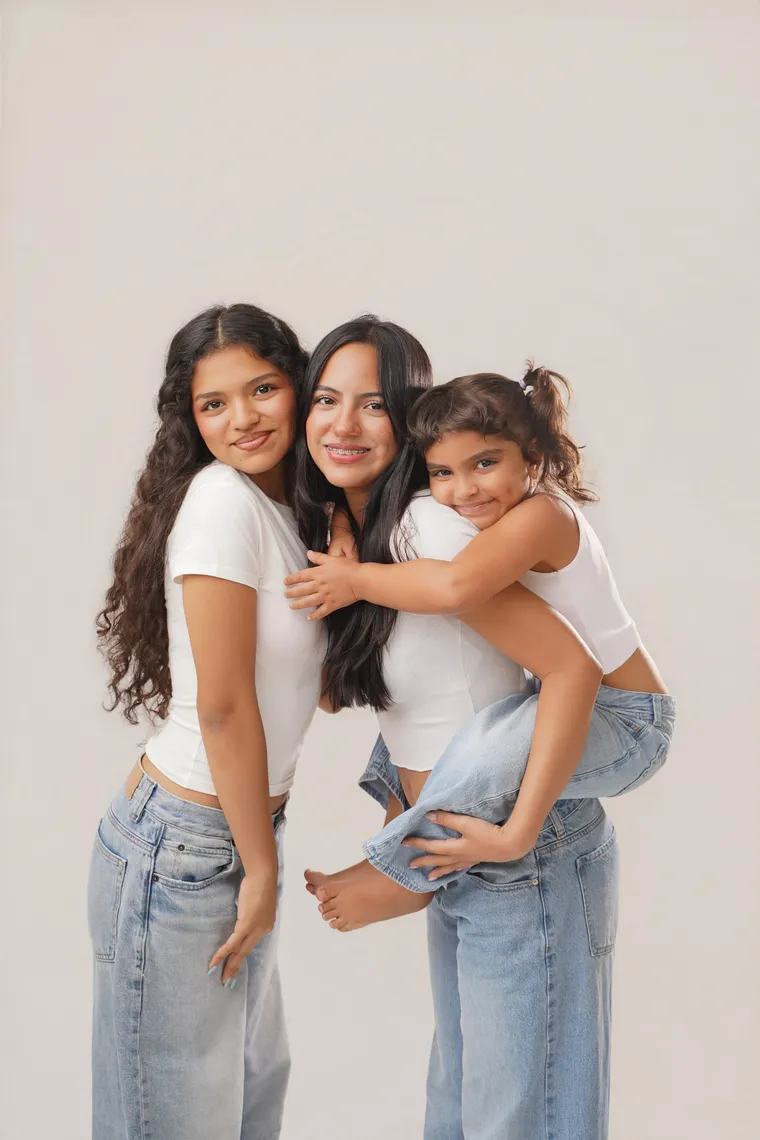 Dos personas de blanco y vaqueros abrazadas, una lleva a una niña a caballito, de Photoluv Studios en Miami